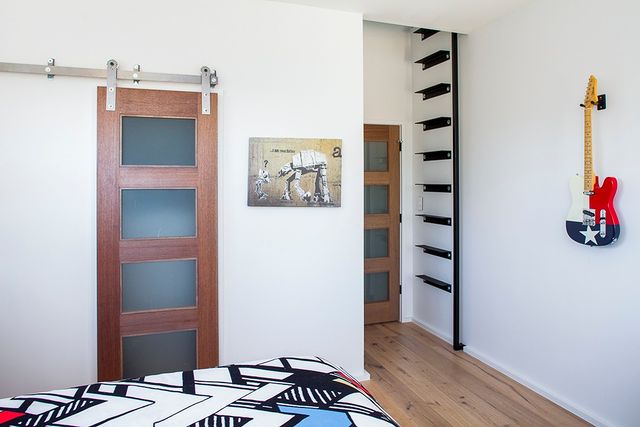 Modern bedroom with a ladder leading up to a secret loft area