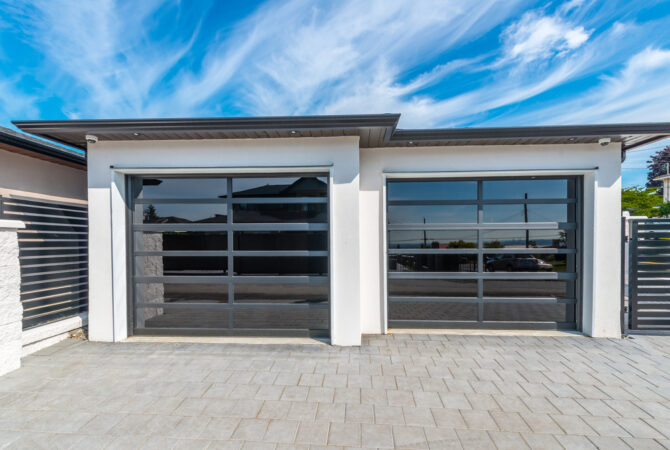 Two connected single car garages with glass garage doors