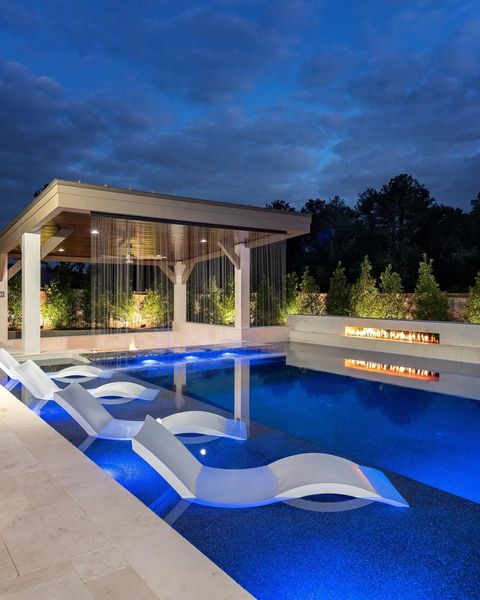 Luxury pool with tanning chairs at night. Photo by Instagram user @pool.nation