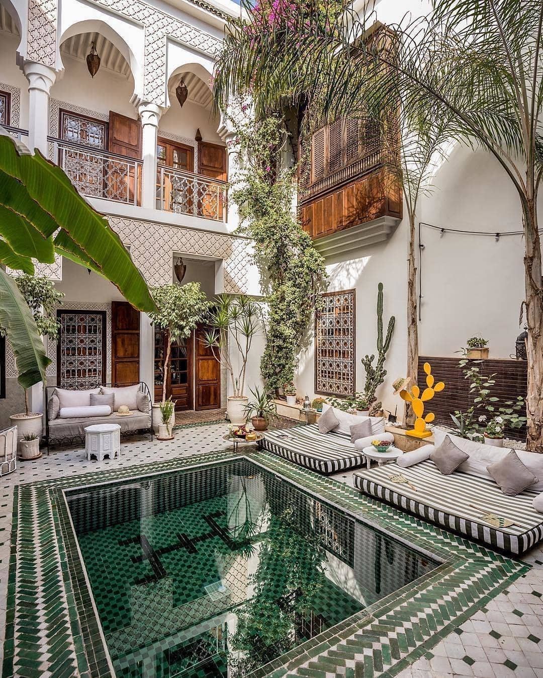 Moroccan style outdoor area with green mosaic tile pool and lounging pillows. Photo via instagram user @luxvtrealestate