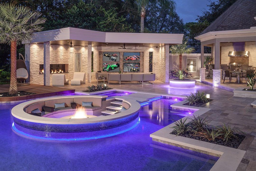 backyard pool with purple track lighting and a conversation pit. photo via Instagram user @ryanhughesdesign
