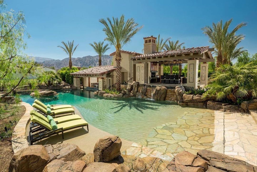 zero entry pool with natural rock tiling, lounge chairs, and palm trees. photo via Instagram user @matrixrock