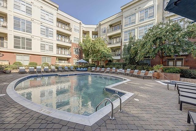 3 story apartment buildings surround a pool, patio, and deck chairs on two sides at a Glenwood South, Raleigh apartment complex. Photo via Instagram user @712tucker.