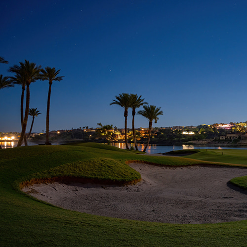 Las Vegas golf course with lights and lake in the distance at dusk