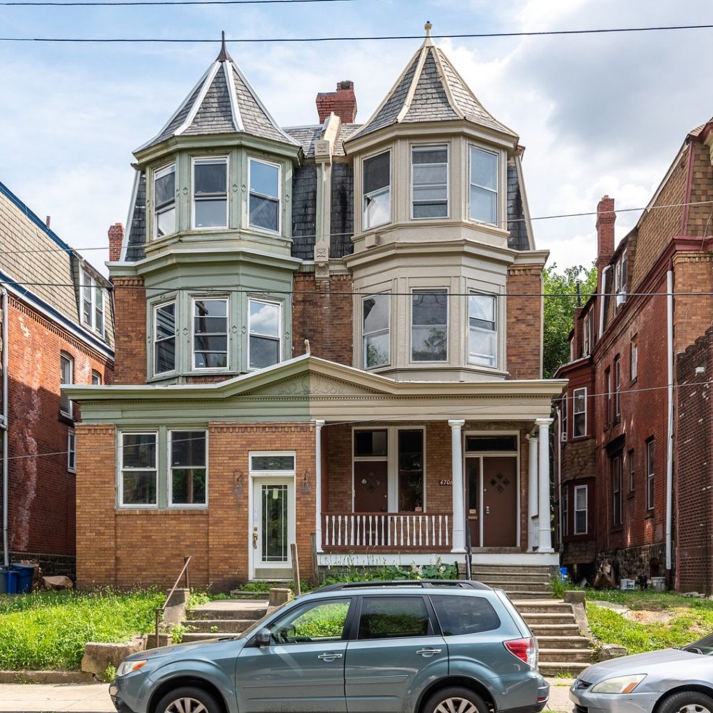 A queen anne style home with two towers, a front porch, and a set of sidewalk stairs. Photo via Instagram user @cityblockteam