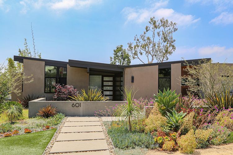 Mid-Century Modern home with bushes and landscaping in front, located in Solana Beach, California