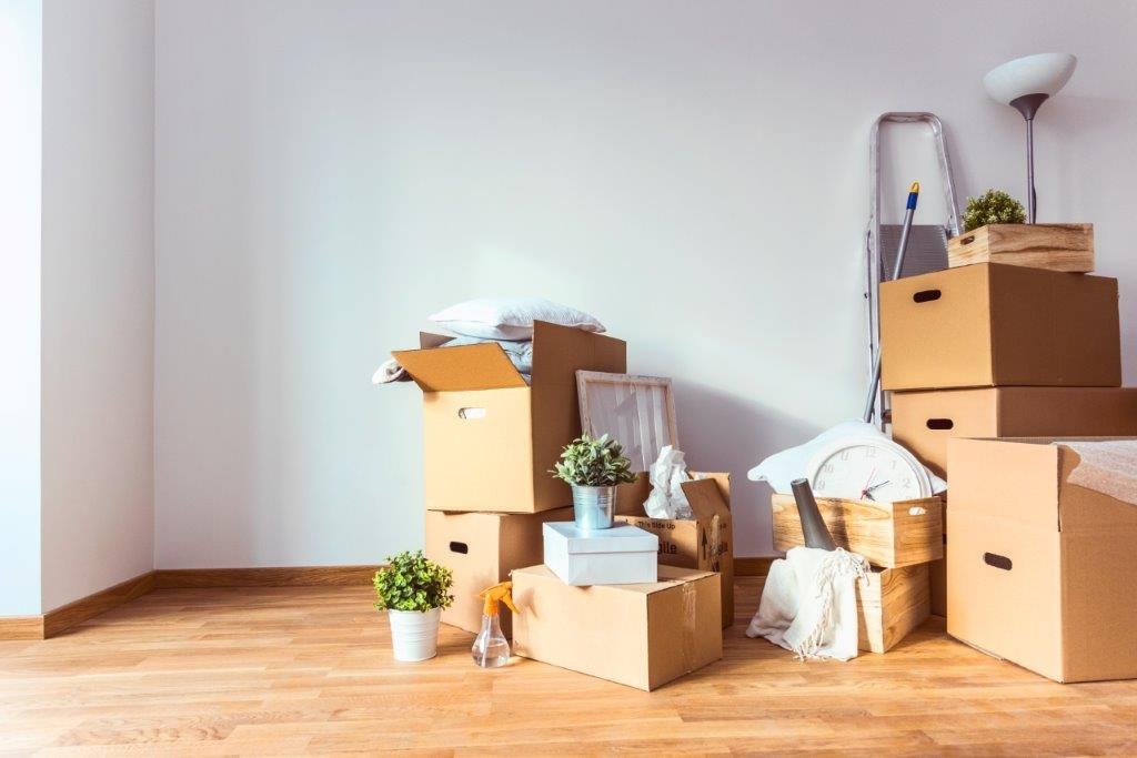 moving boxes stacked along wall. photo via @bluebellrelocation via @