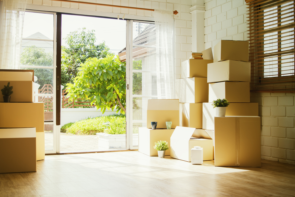 Packed cardboard boxes next to a sliding glass door.