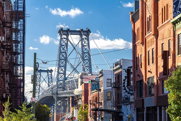 NYC Brownstone buildings and telephone poles with Williamsburg Bridge in background