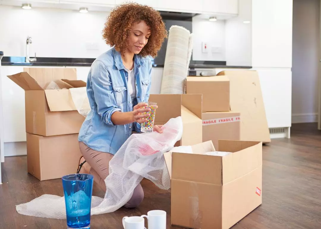 Young adult woman packing moving boxes