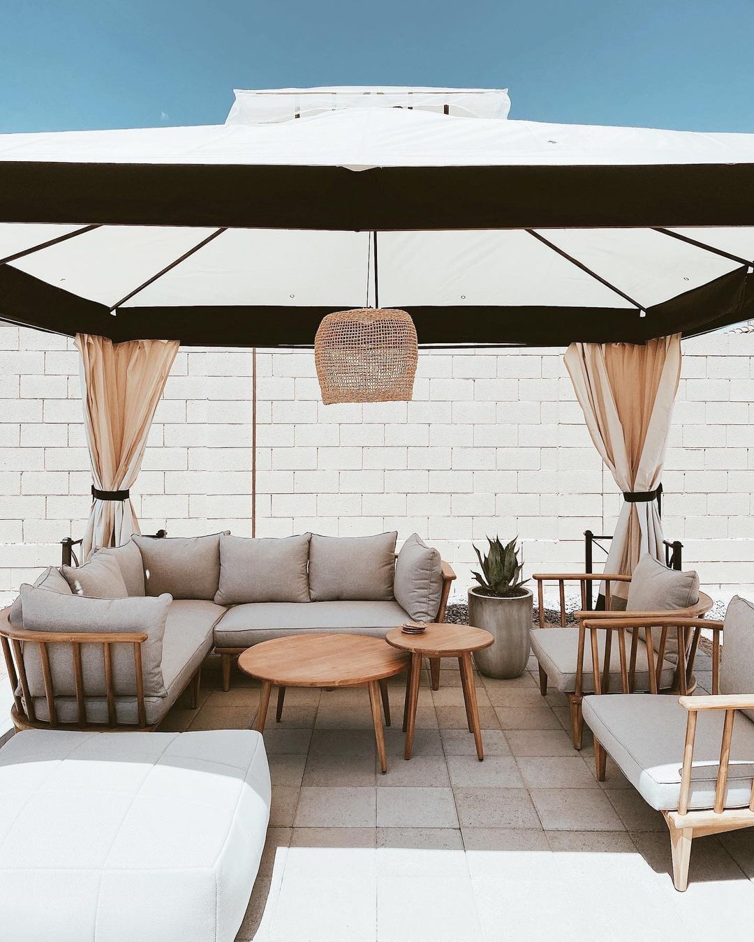 A white masonry wall next to a backyard gazebo. Photo by Instagram user @sunjoylife