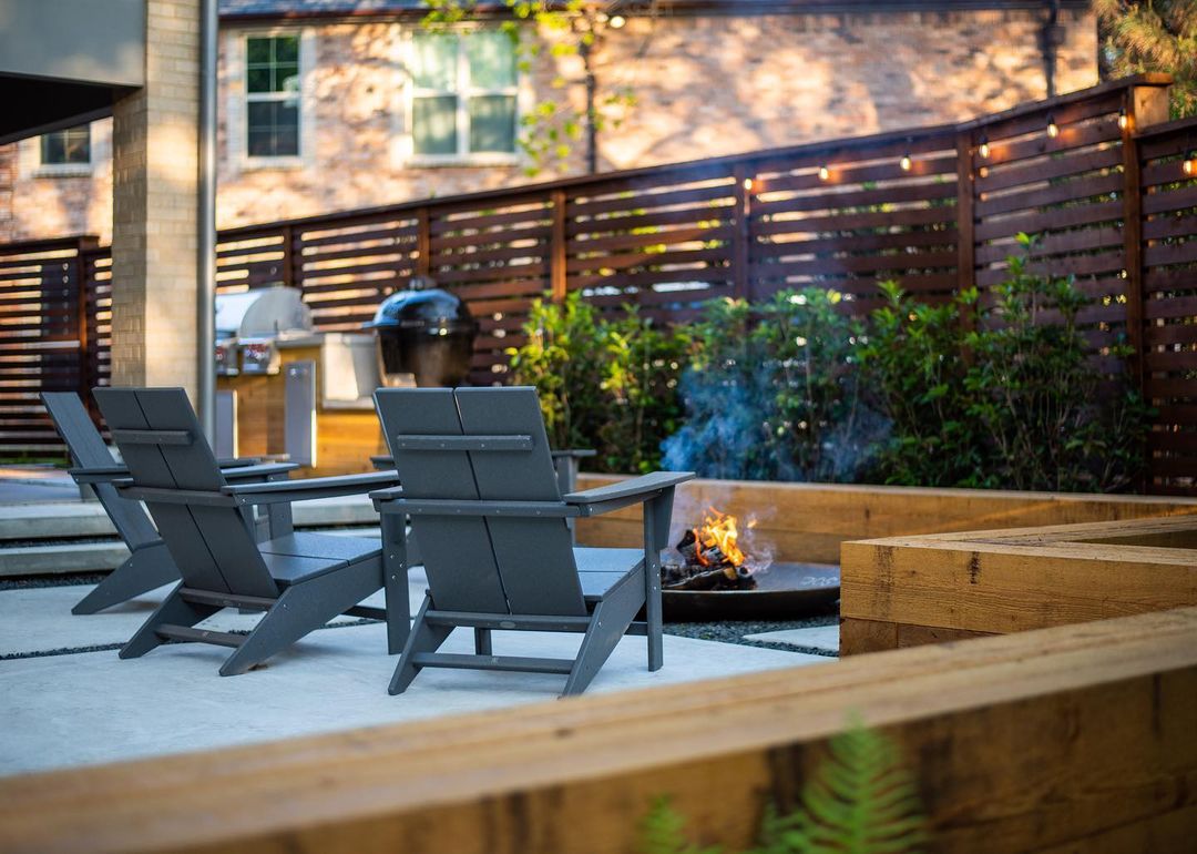 metal fire pit in ground with grey chairs