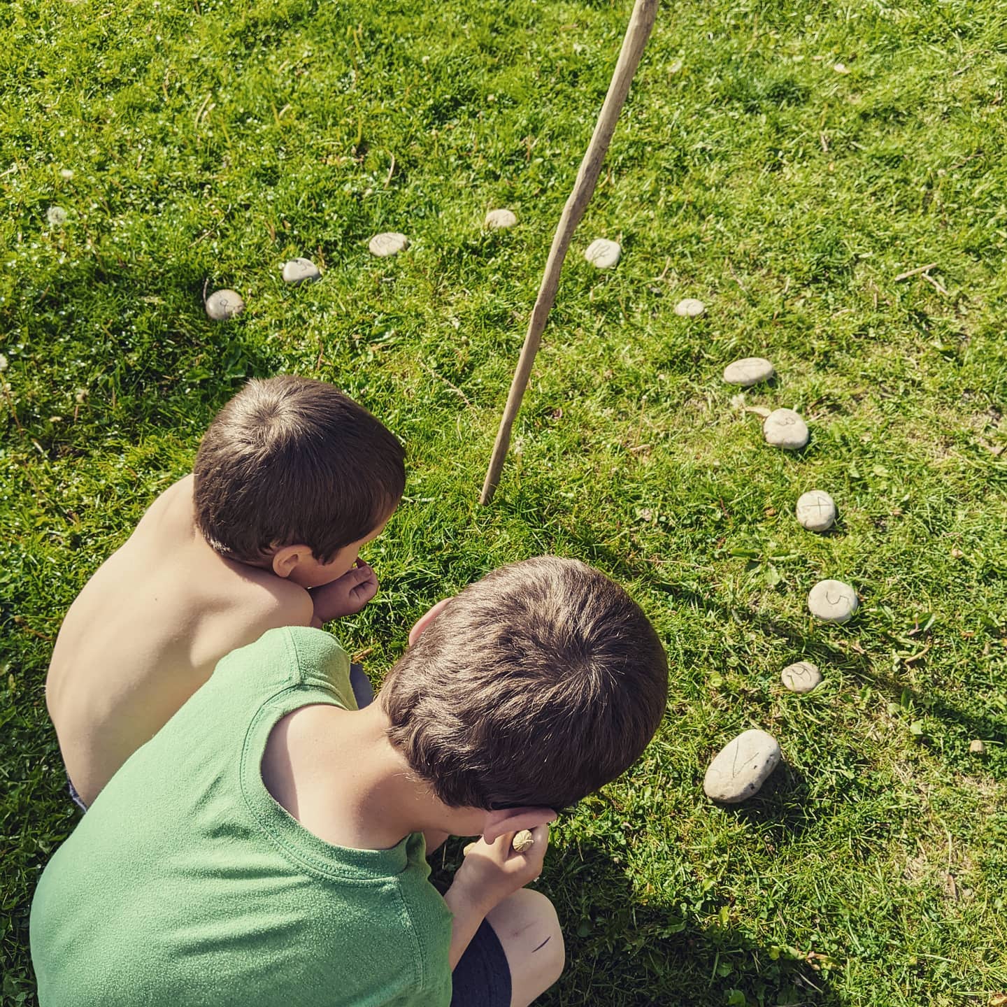 Children looking at an outdoor DIY sundial. Photo by Instagram user @our.forest.homeschool
