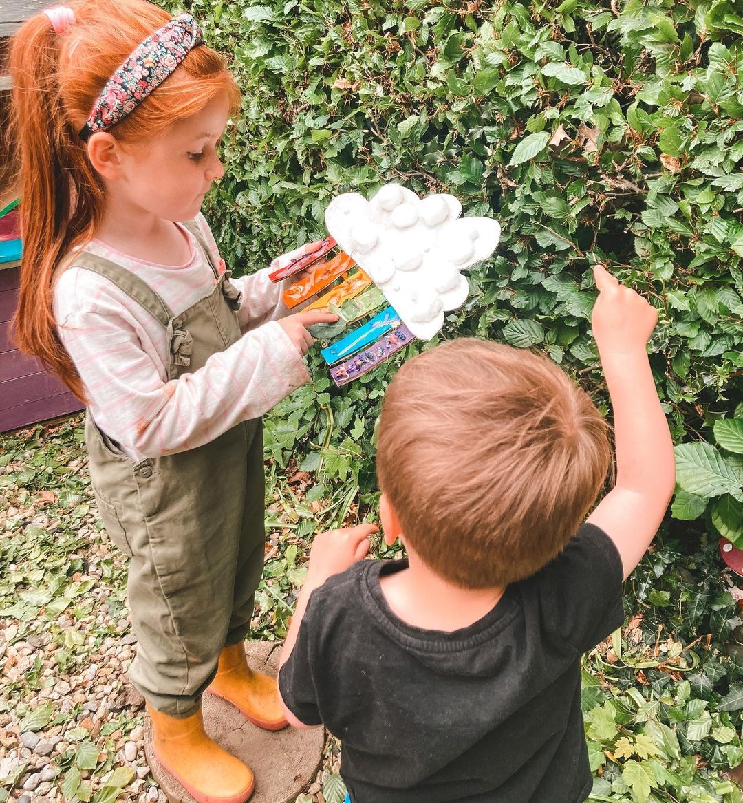 Children looking at a rainbow scavenger hunt board. Photo by Instagram user @heyho_sach_tho
