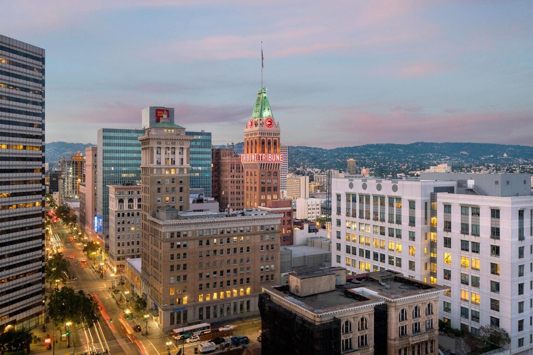 Oakland sunset skyline featuring the Tribune tower. Photo by Instagram username @oaklandmarriott