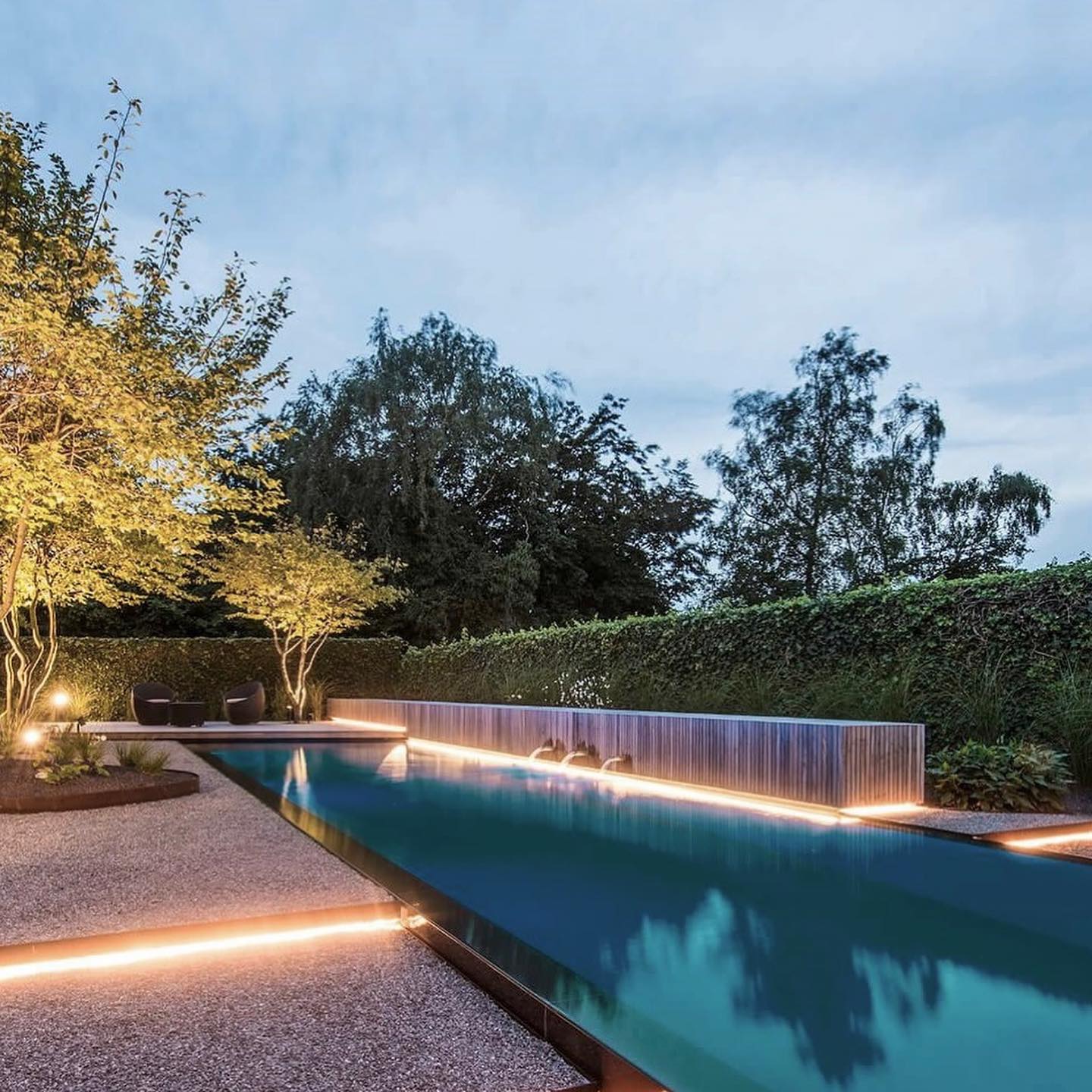 A backyard pool that has some edges lit up with strip lights. @mintlighting_design.