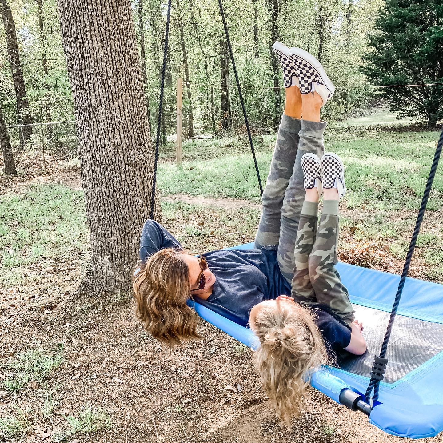 Mom and child relaxing on a large tree swing. Photo by Instagram user @khrista.tripp