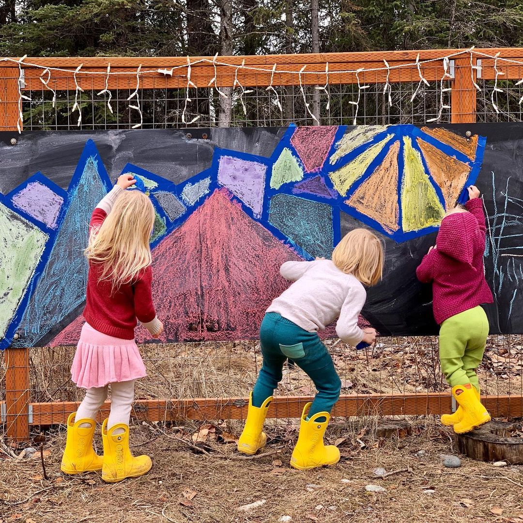 Children using chalk on an outdoor chalkboard canvas. Photo by Instagram User @alaskawildlings