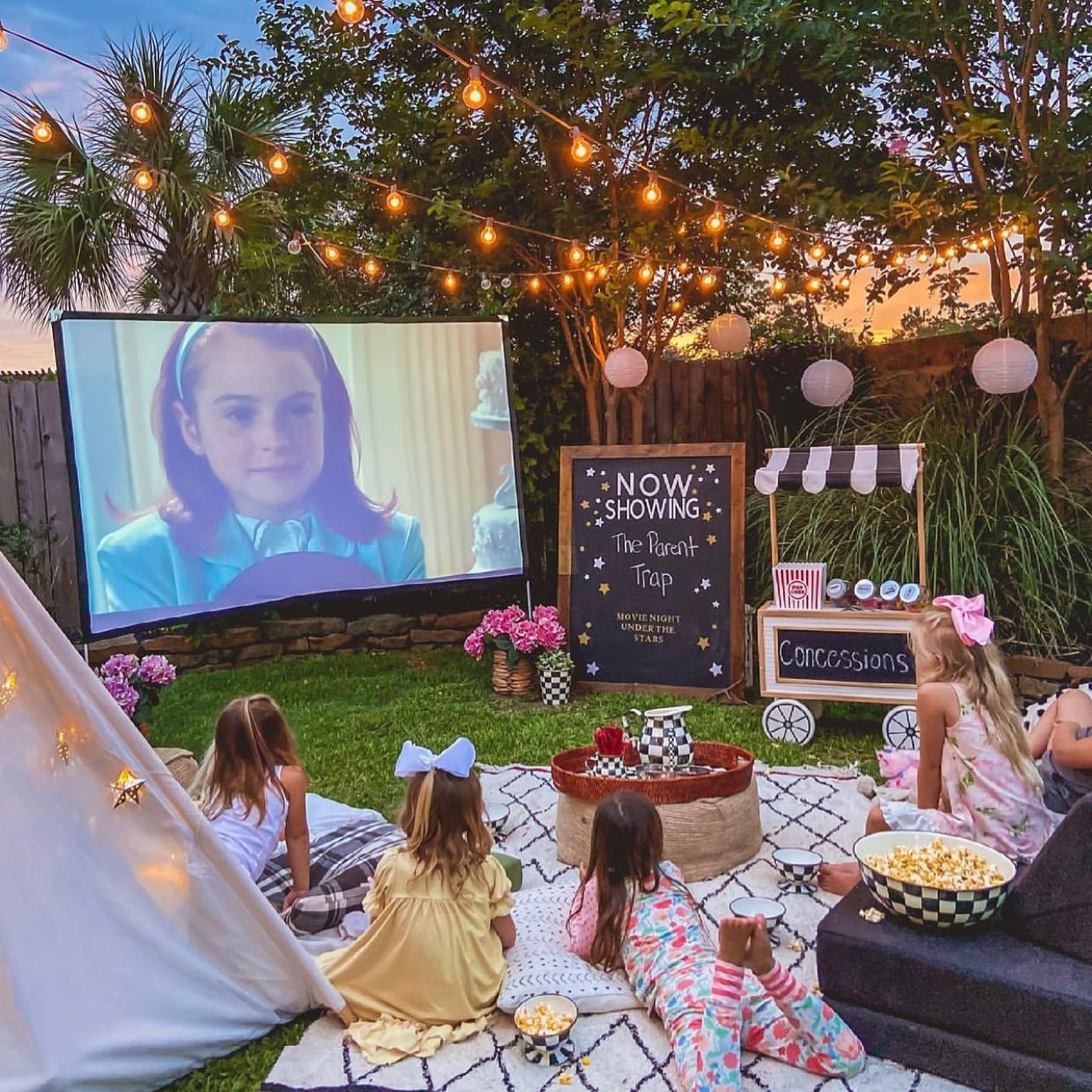 outdoor movie theater with projector screen. Photo by Instagram user @glampingalabama