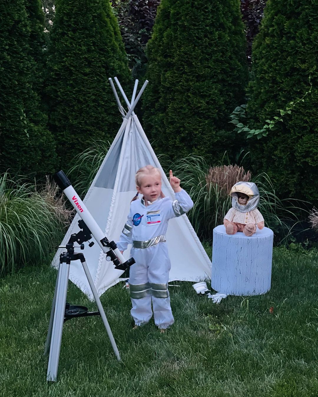 Child pointing at the sky with an outdoor telescope. Photo by Instagram user @delsitfamily