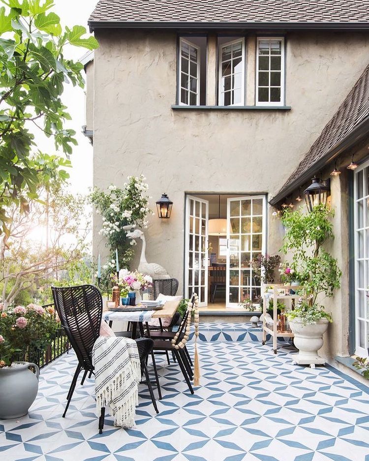 A backyard patio with detailed tile patio flooring. Photo by Instagram user @alexwrighthomes