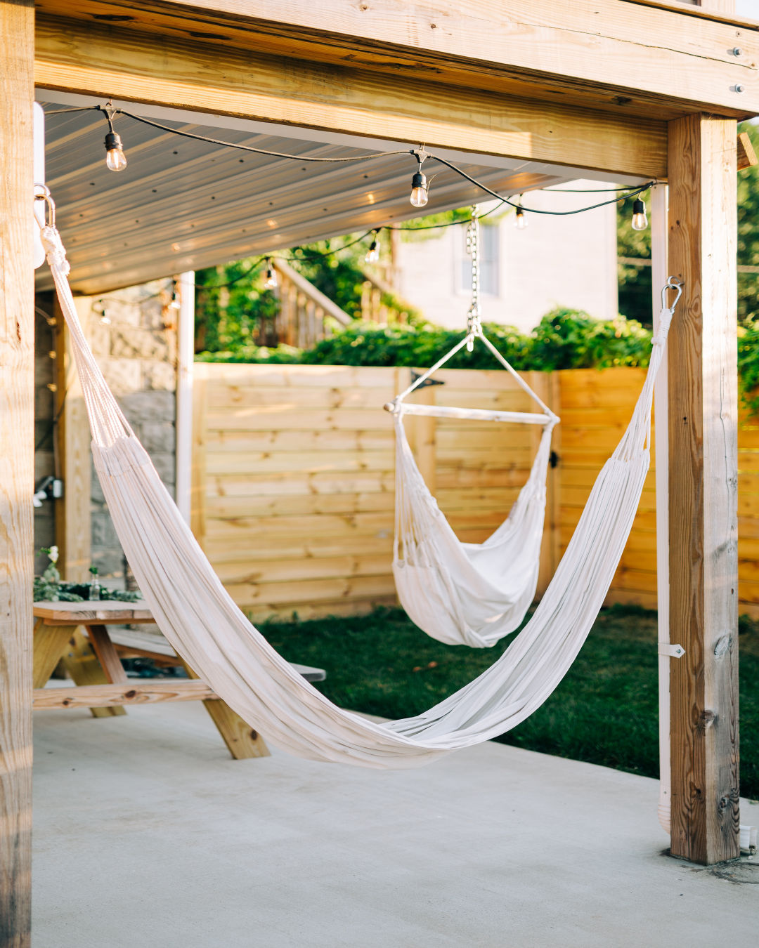 Two hammocks hung from the ceiling of a backyard patio. Photo by Instagram user @scotthansenrealtygroup