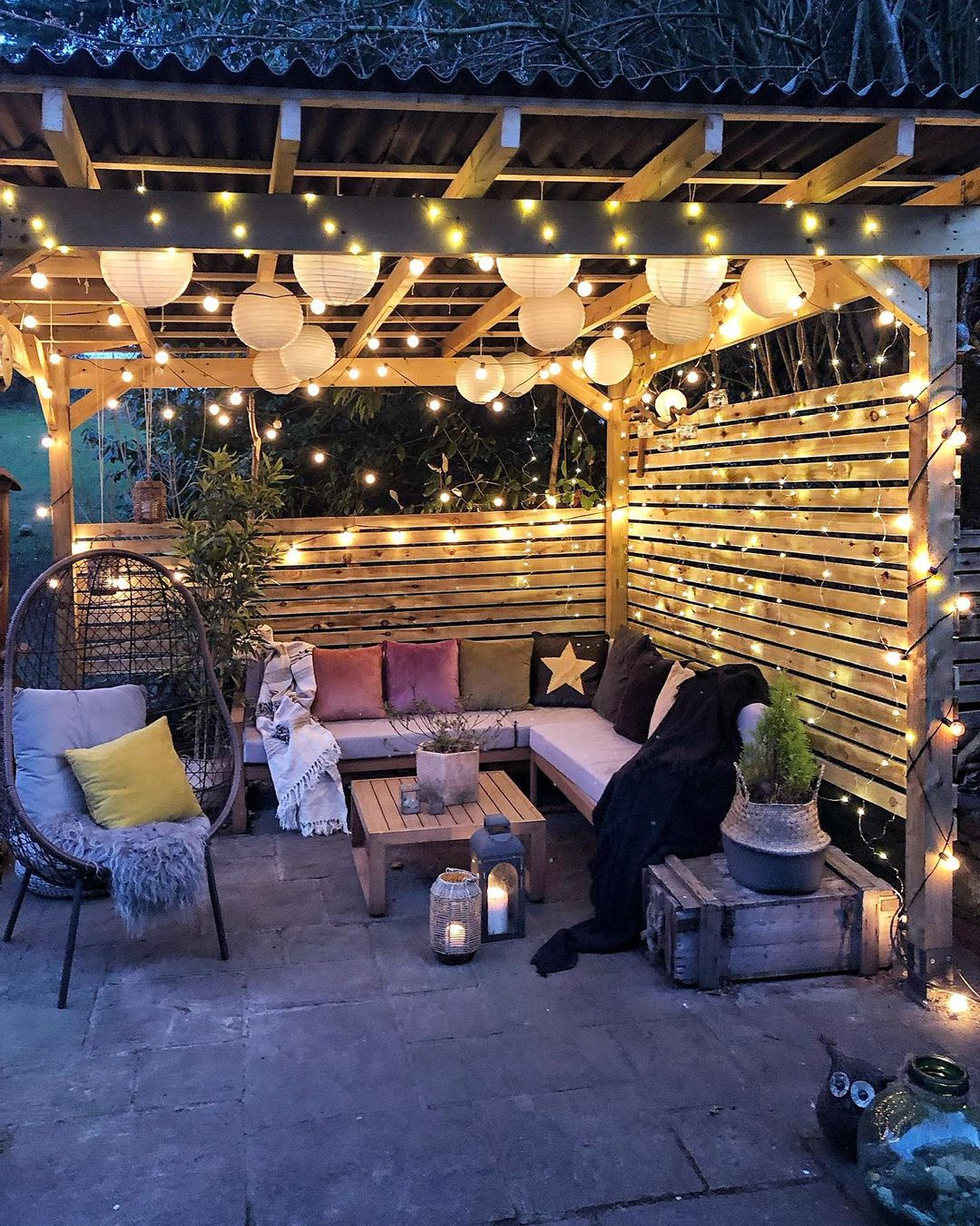 A covered backyard patio decorated with string lights. Photo by Instagram user @mydarkhome_