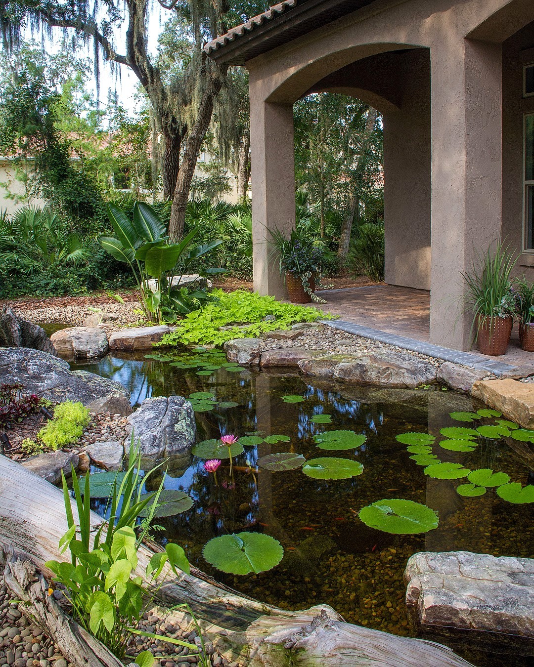 A small pond water feature next to a backyard patio. Photo by Instagram user @aquascape_inc