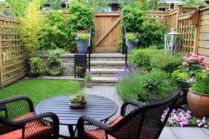 A backyard patio and garden with furniture and plants.