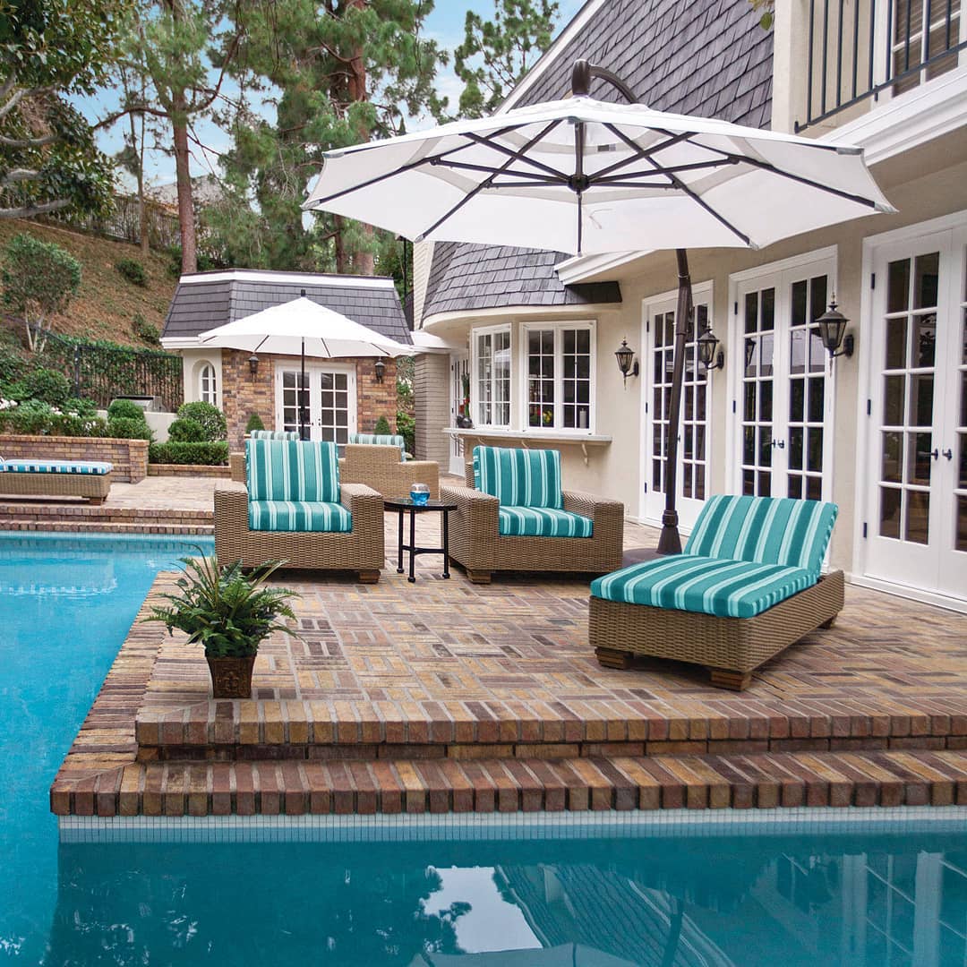 Poolside seating with umbrellas above the lounge chairs. Photo by instagram user @hauserfurniture.