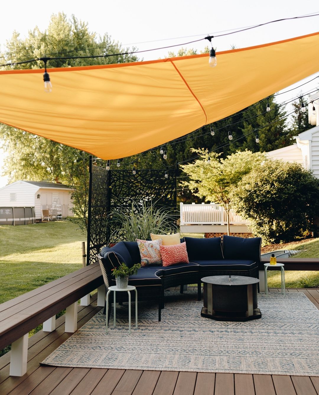 Sail shade above an outdoor seating set in a spacious back yard. Photo by Instagram user @brookside.brothers.