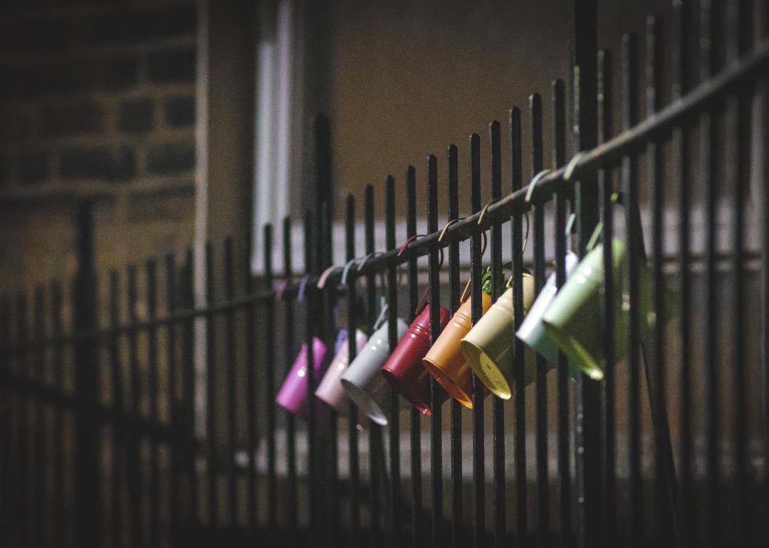 Colorful buckets hanging on iron fence