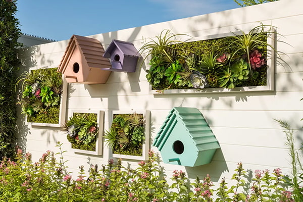 Colorful birdhouses and vertical gardens on a white wall