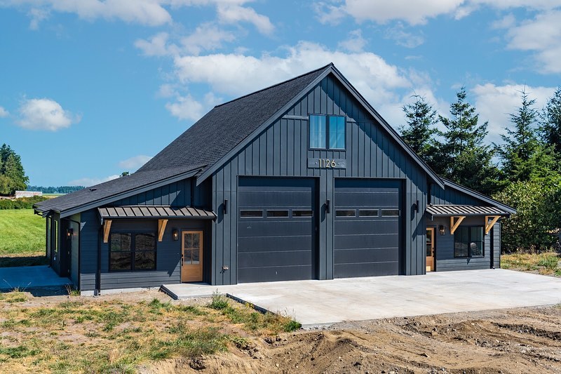 Black shouse with large double garage doors. Photo by Instagram user @adhouseplans