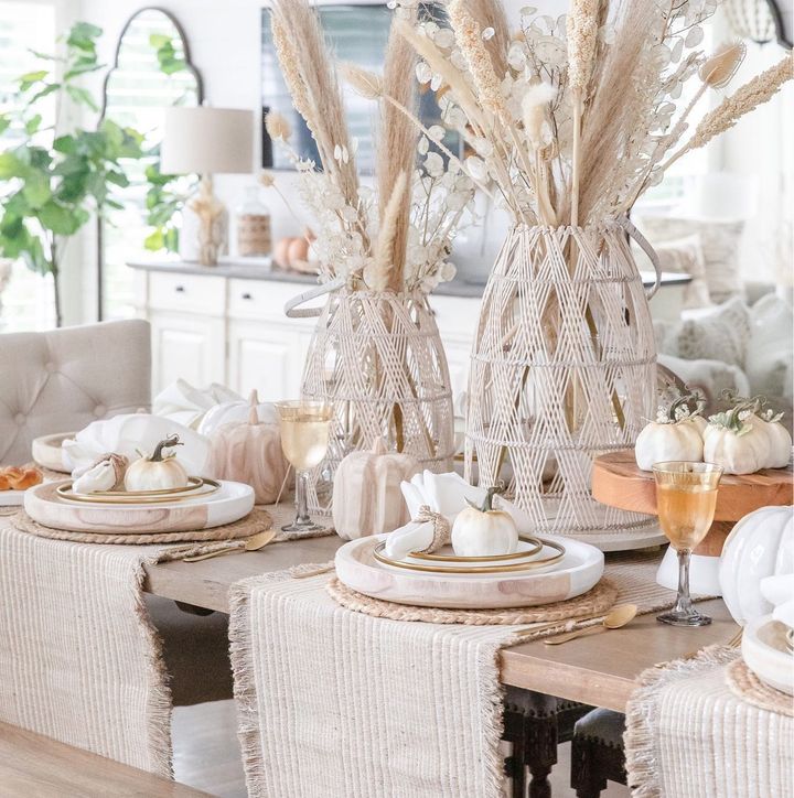 Neutral table with fall decor including pumpkins and other autumnal foliage as centerpieces. Photo by Instagram user @jennyreimold.