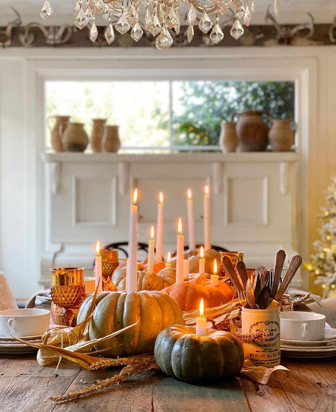 Table setting with pumpkins and other gourds being used as candleholders. Photo by Instagram user @toni_marianna.