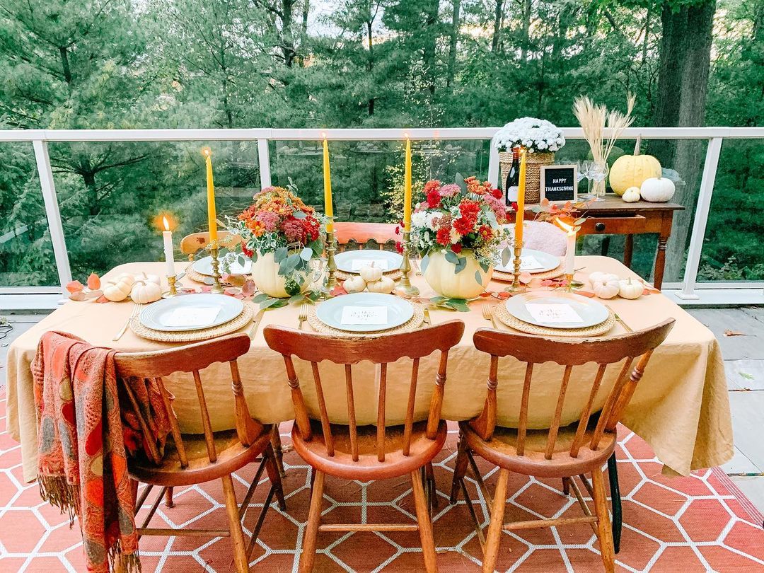 A small table with plates, candles, and fall-themed decor accents. Photo by Instagram user @june_and_dot.