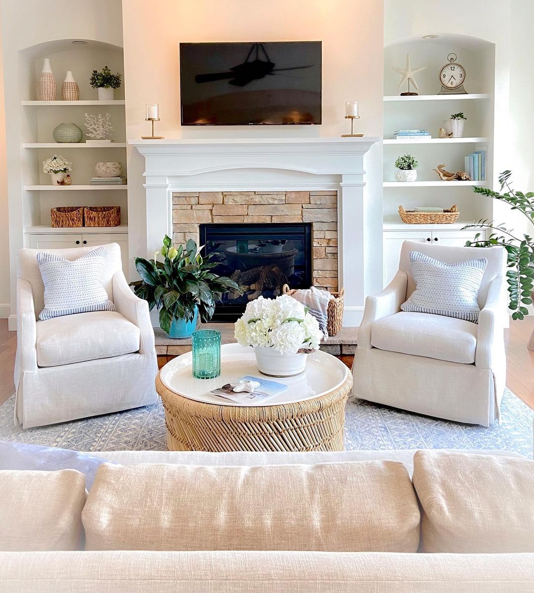 Neutral living room with fireplace, built in shelving, and decorated coffee table. Photo by Instagram user @wowilovethat