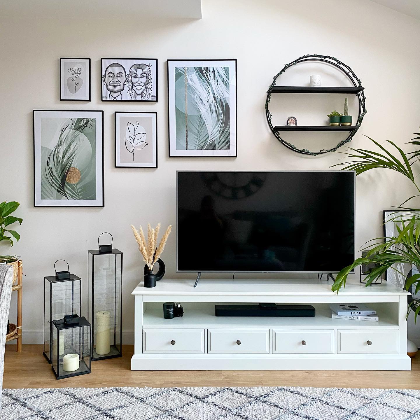 TV stand with hanging wall art and circle shelving. Photo by Instagram user @luxfordinteriors