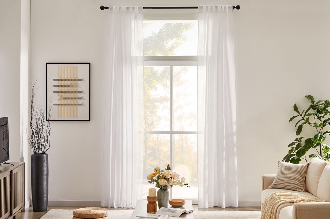White living room with large window and plants. Photo by Instagram user @nicetowncurtains