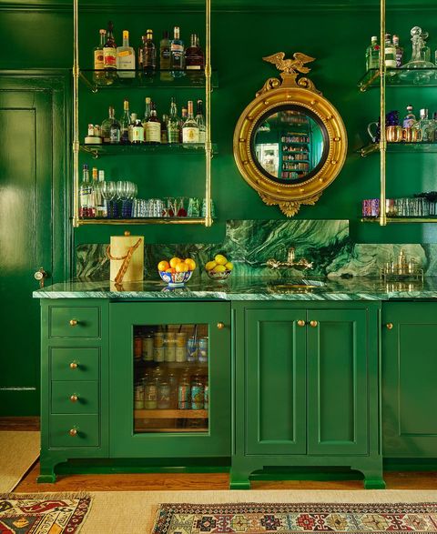 A very green room with the walls and the furniture being painted a emerald green.