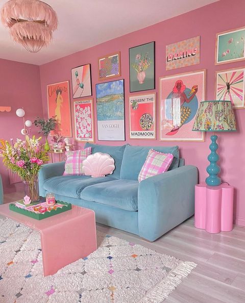 A pink room with pink walls, blue couch and several pink appliances.