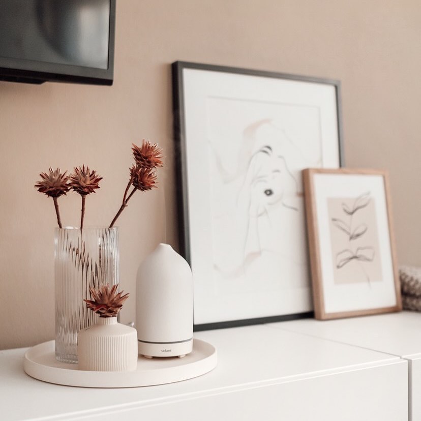 A tabletop arrangement of decor with art and an aromatherapy diffuser. Photo by Instagram user @volantaroma.