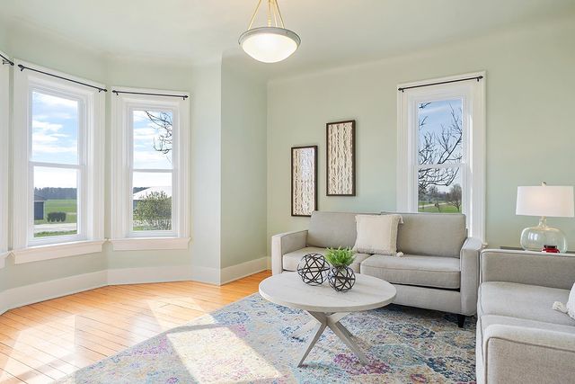 A light green room with two couches and a small table in the center of the room.
