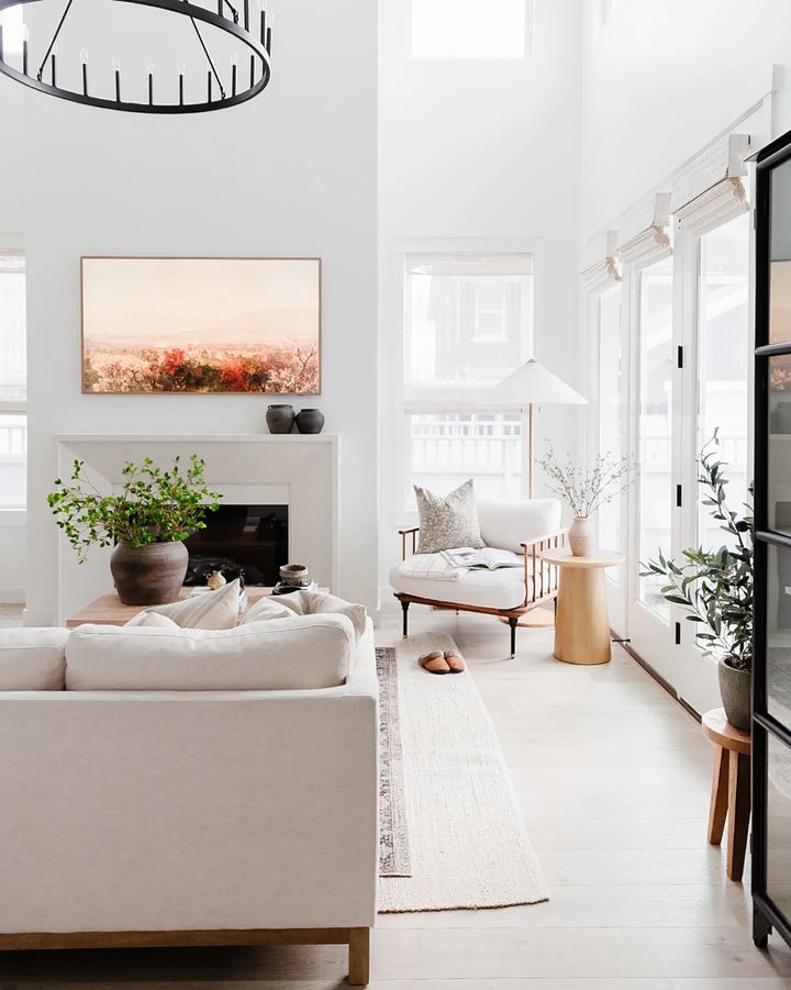 A bright living room space with lots of natural light coming in through the windows, as well as artificial light being cast off of a ceiling lighting fixture above. Photo by Instagram user @mari_hedrick.