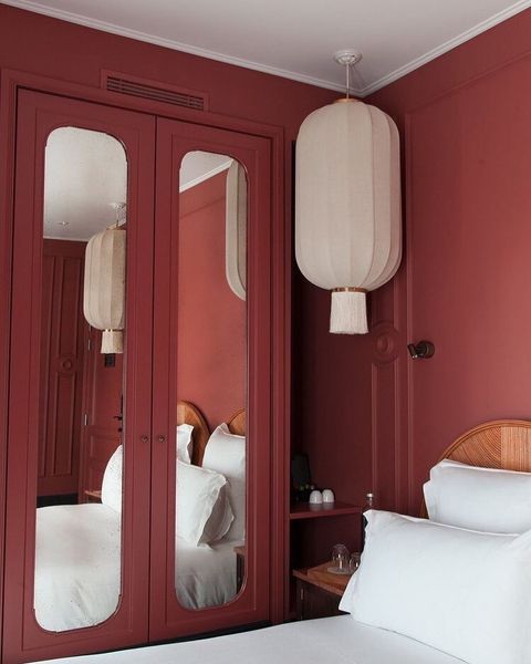 A room with red painted walls and a mirror on one side of the wall.