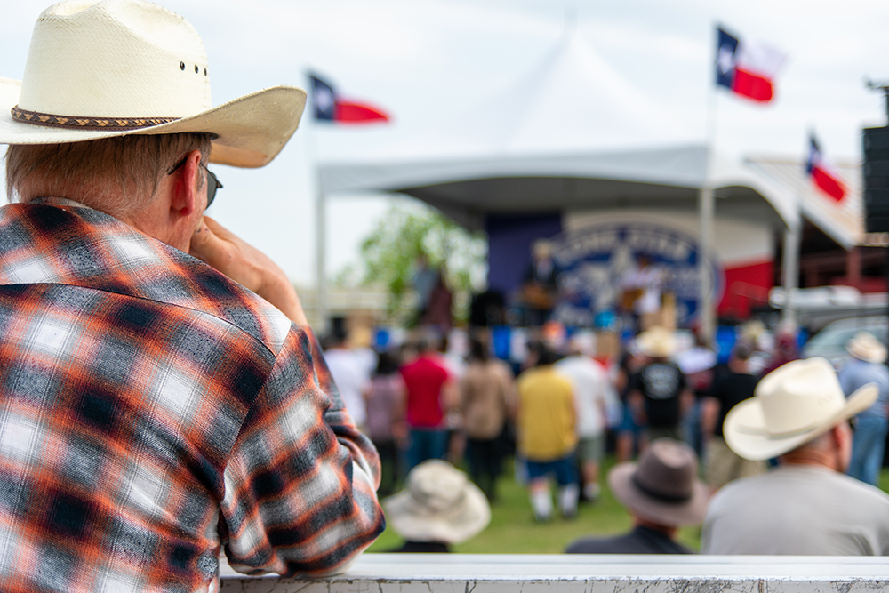 man in cowboy hat watching outdoor music