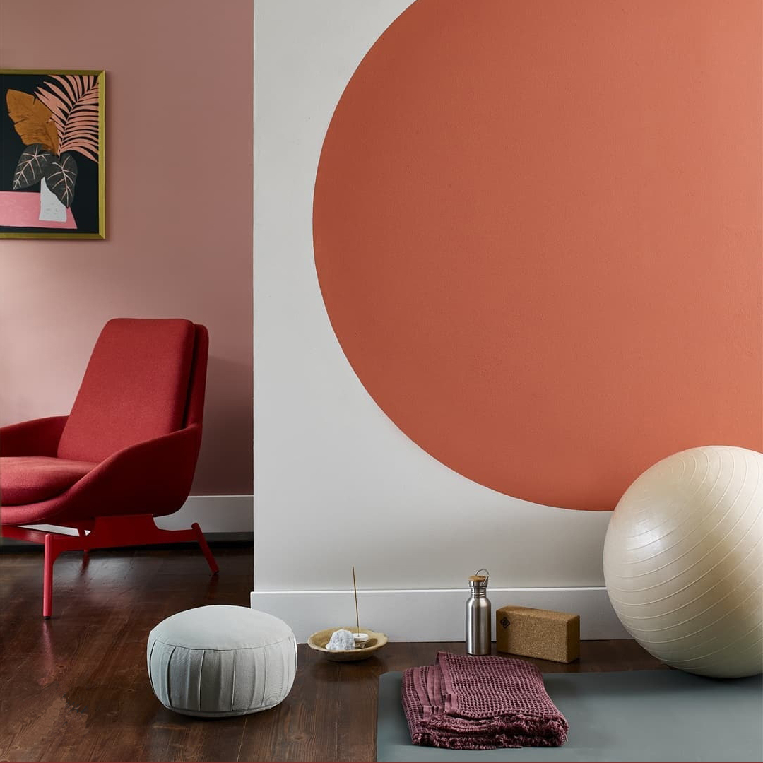 Yoga room with red and pink colored accents on the walls and chairs. Photo by Instagram user @sam.grigginteriors