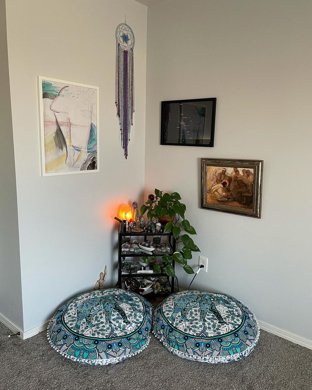 Meditation corner with two poufs and art hung on the walls. Photo by Instagram user @amethystwarriorqueen
