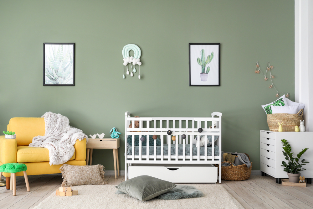 A baby nursery with green walls and decorations